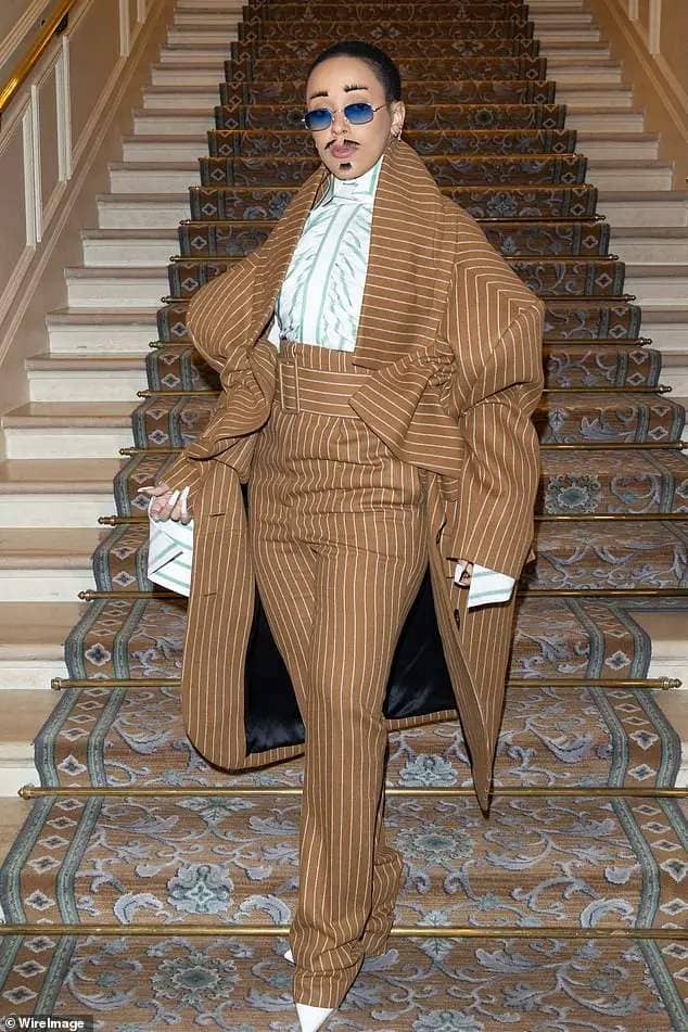 Walk this way: Doja turned heads in her quirky androgynous look as she rocked up in high-waisted pinstripe trousers and a matching oversized coat which swamped her slender frame