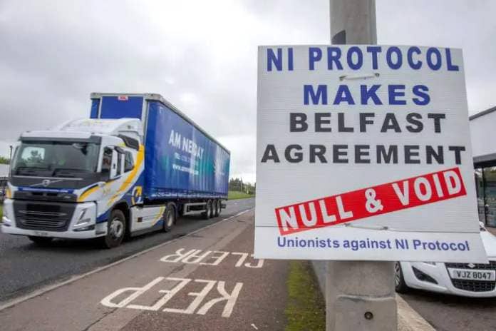A lorry passes an anti Northern Ireland protocol sign as it is driven away from Larne port, north of Belfast