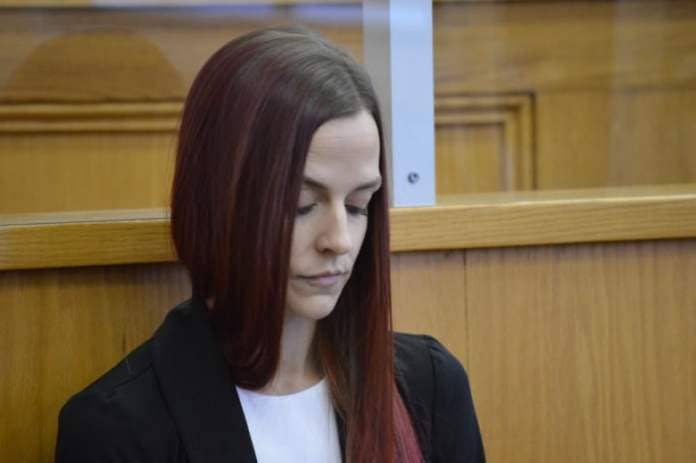 A woman looks down in court