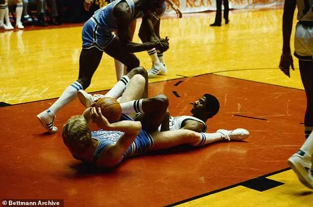 Indiana State's Larry Bird (L) and Michigan State's Earvin Johnson are a tangle on the floor under the Michigan State basket early in the NCAA national basketball championship game. Johnson, ready to shoot a basket, tripped over Bird's foot