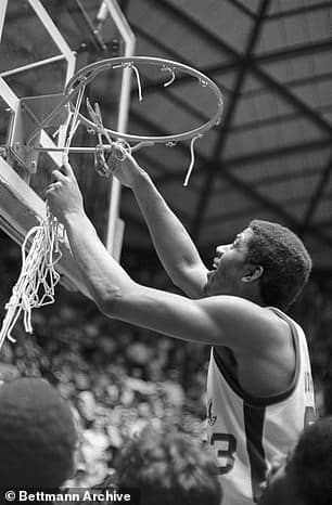 Earvin Johnson, Michigan State's most Valuable Player Award winner at the NCAA basketball championship game at Utah University, uses a pair of scissors to cut off the net from the hoop after the Spartans won the National Championship