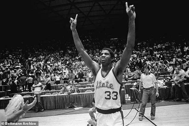 Michigan State guard Earvin Johnson raises his hands and holds up one finger to denote that Michigan State is number ONE after they beat the Indiana State Sycamores 75-64