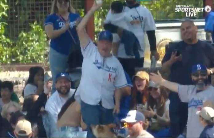 One fan took the ball from the dog and held it up in celebration.