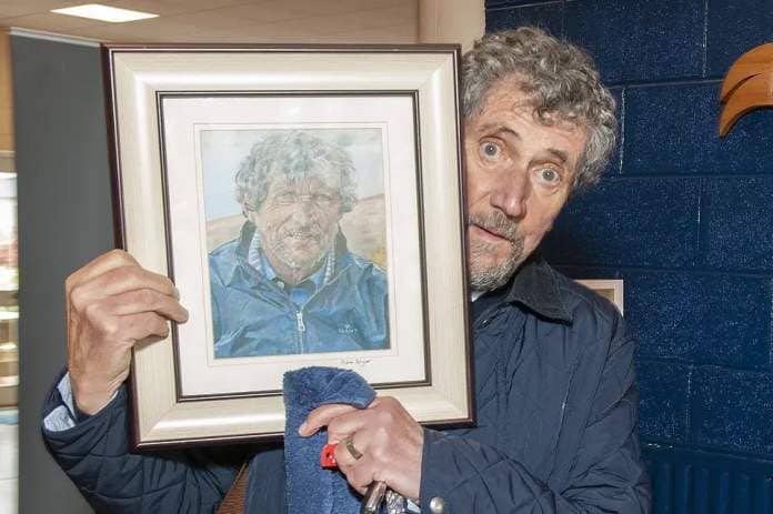 Charlie Bird delighted with the painting by young artist Aidan Bolger from sixth year who won a special merit award in the Texaco Art Competition pictured in Colaiste Bhríde, Carnew on Wednesday. Pic: Jim Campbell
