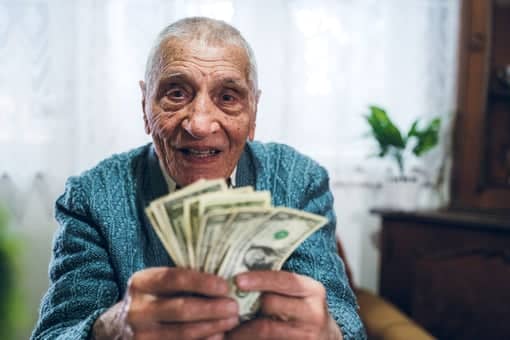 Senior Man Counting Cash Money Bills Social Security Retire Invest Inflation COLA Getty