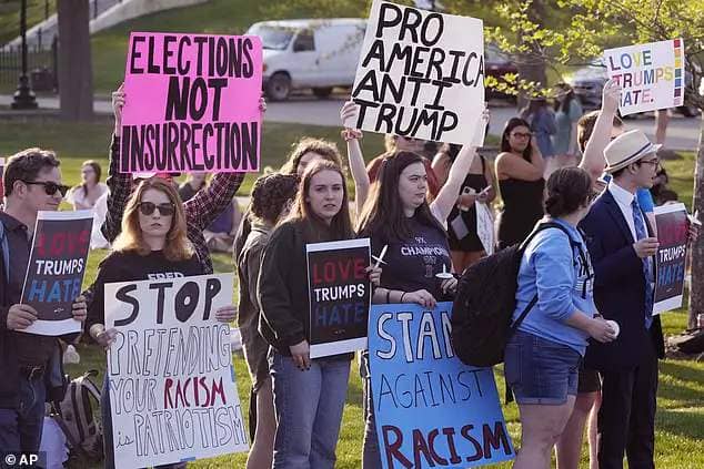 People protest outside a building on the campus of Saint Anselm College hosting a CNN televised town hall gathering with former President Donald Trump