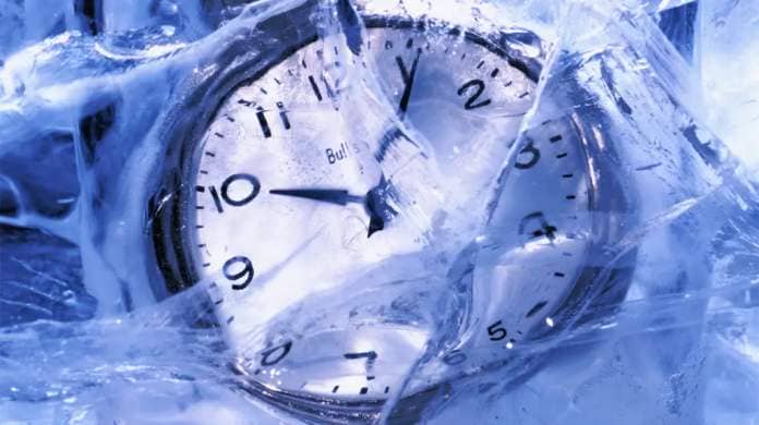 An analog clock frozen in ice