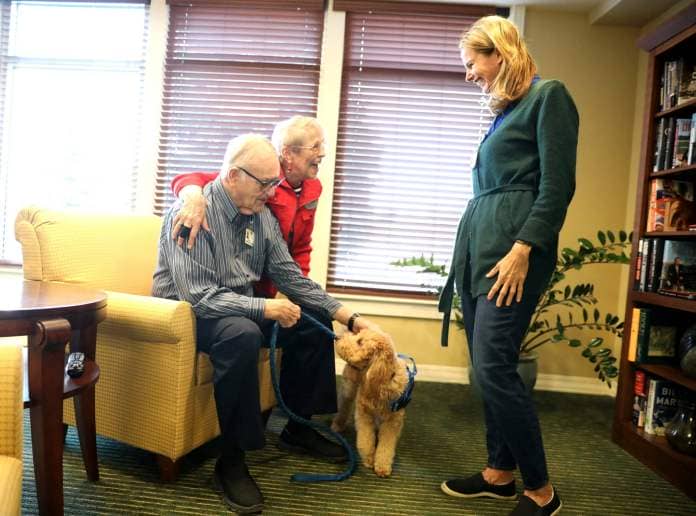 GreenFields of Geneva residents Bob and Judie Knott pet Grizzly Bear as Grizzly Bear’s owner and handler Leslie Paquette looks on. Paquette is the life services manager at the senior living community and had her 4-year-old mini golden doodle trained to be a therapy dog.