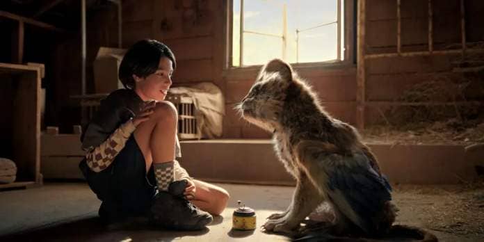 a kid sits calmly next to a furry creature in a scene from chupa, a good housekeeping pick for best kids&#39; movies 2023