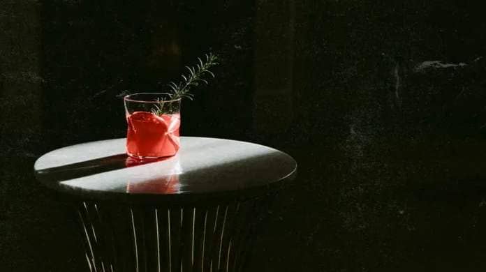 An alcoholic drink sits on a small table