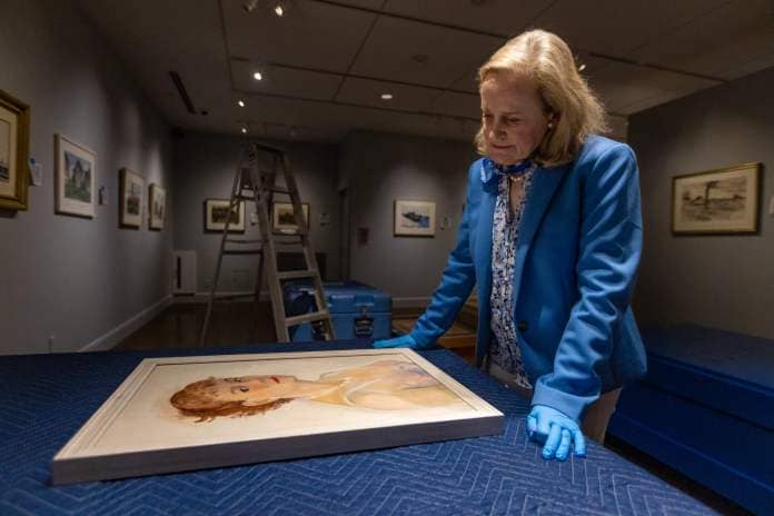 Curator Elliot Bostwick Davis looks at Josephine Hopper’s self-portrait before it’s to be hung on the wall as part of the exhibit “Edward Hopper & Cape Ann: Illuminating an American Landscape” at the Cape Ann Museum in Gloucester. (Jesse Costa/WBUR)