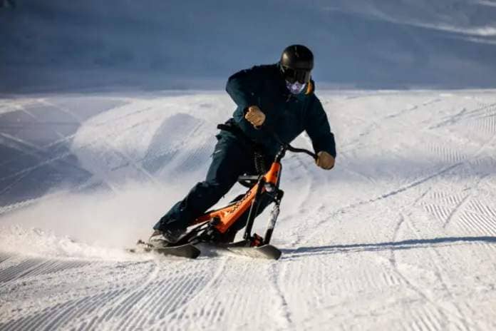 a man carves down a slope on a snow go shift 