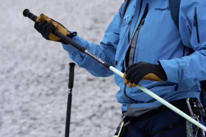 a figure holds a mountainFLOW pole on a snowy slope