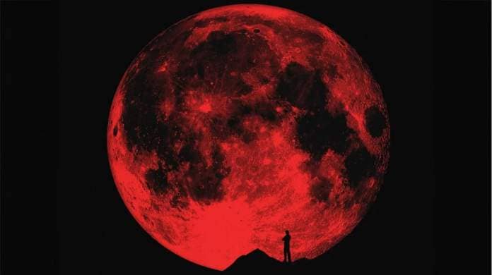 Men's silhouette against the background of the full blood moon