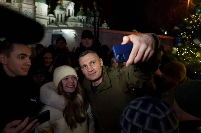 Mayor of Kyiv Vitali Klitschko takes selfies with people in the St. Sophia square, next to a newly built Christmas tree in Kyiv (AP)