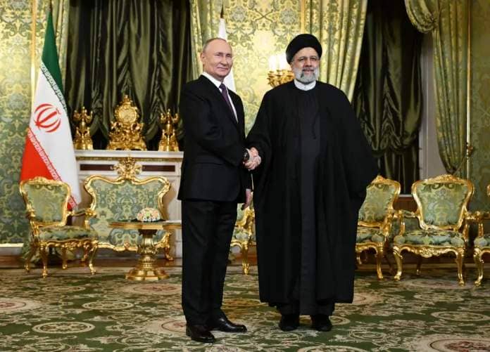 Russian President Vladimir Putin shakes hands with Iranian President Ebrahim Raisi during their meeting at the Kremlin in Moscow (EPA)