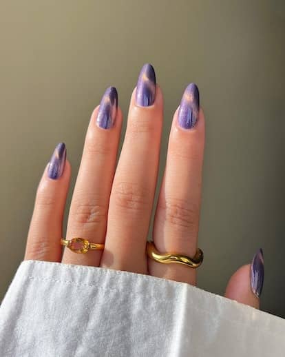 Cat eye nails painted with purple metallic polishes are on-trend.
