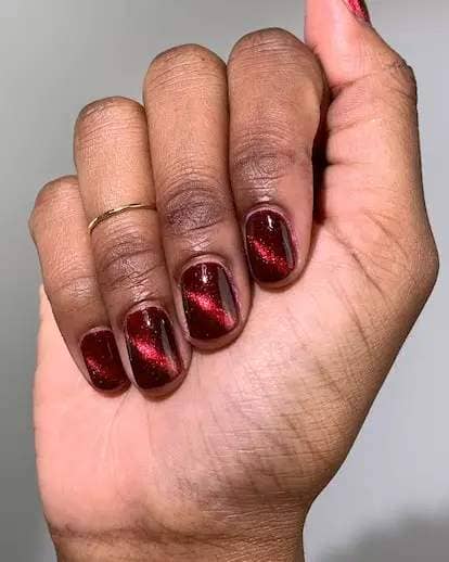 Elevate your "red nail theory" manicure with cat eye line details on each tip.
