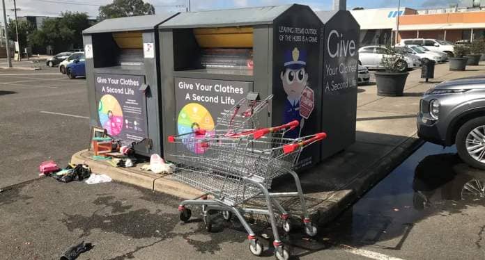 Trolleys in front of two charity bins.