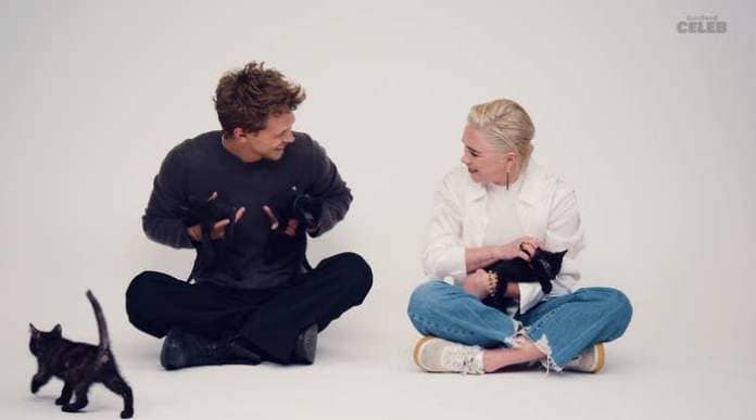 Austin Butler and Florence Pugh people sitting on the floor, interacting playfully with kittens around them, in a studio setting