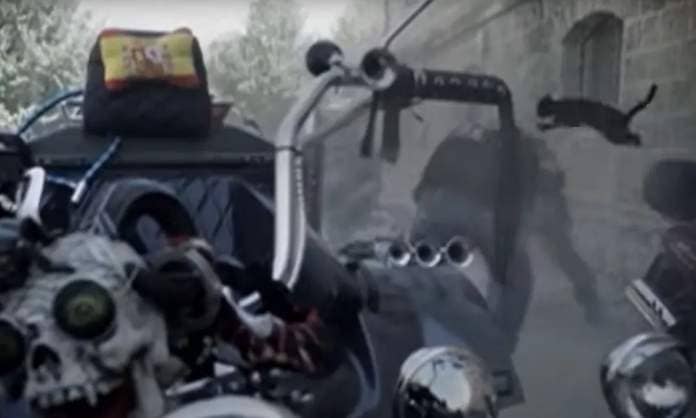 A screencap from 2013’s Corpse Grinders 3 shows a blurry outline of a black cat leaping on top of a bent-over biker, with a motorcycle dominating the foreground