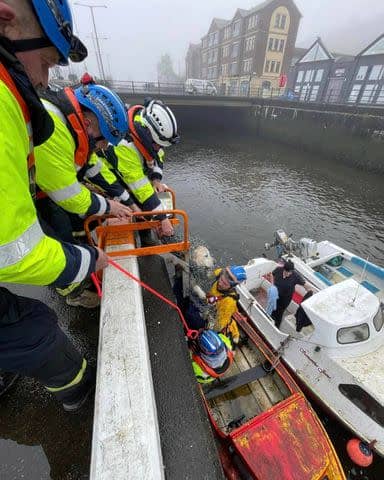 <p>Douglas Coastguard Rescue Team</p> Rescuers removing a golden retriever from harbor waters in the Isle of Man