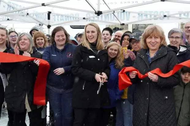 Ashley Mikulsky, CEO of the Animal Rescue League, center with scissors cuts a ceremonial ribbon for the unveiling of the organization's new mobile adoption and clinic vehicle. At right, holding the ribbon is state Sen. Judy Schwank. The ceremony was held Saturday, March 23, 2024, in front the Petco in the Exeter Commons shopping center in Exeter Township. (Alyssa Budock - Animal Rescue League of Berks County)