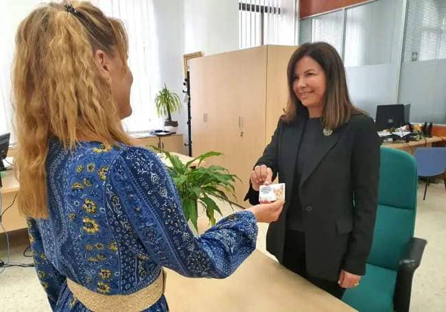 Rincón de la Victoria councillor Lola Ramos hands one of the authorisation cards to a volunteer.