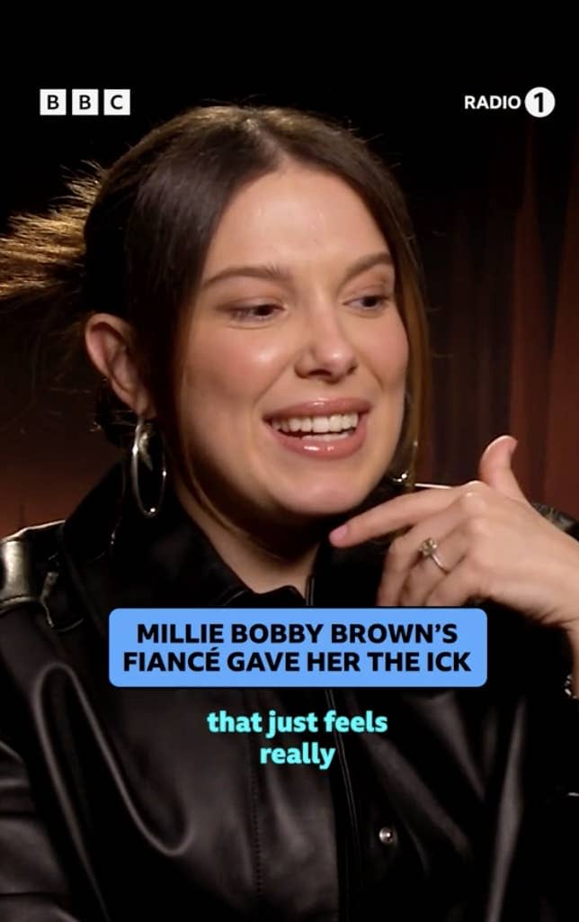 Millie Bobby Brown in a black jacket smiling during an interview, with a caption about her fiancé's fragrance