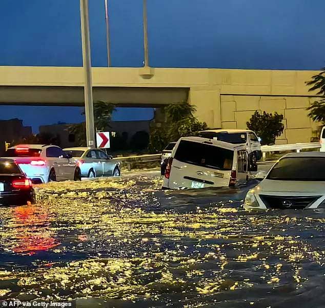 Drivers can be seen navigating their cars through deep flood waters in Dubai