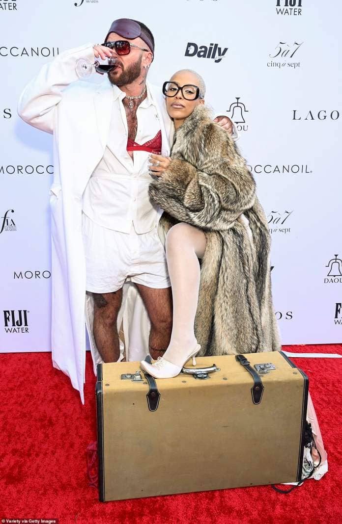 Doja Cat's friend also carried a hefty piece of luggage on the red carpet and a glass of wine