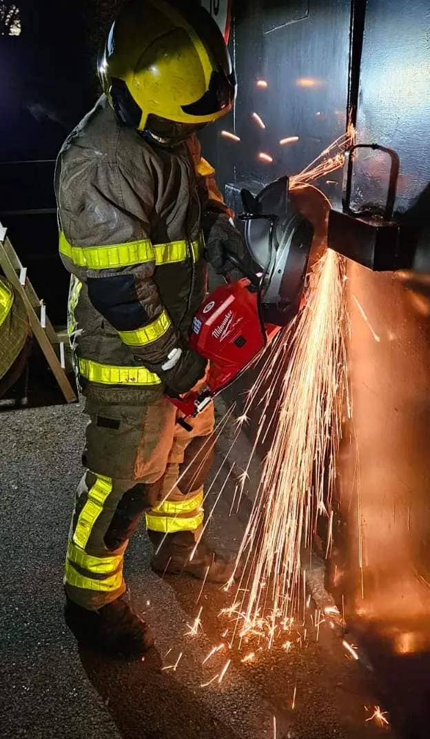 Firefighters works to free Bambi who was stuck under the large container
