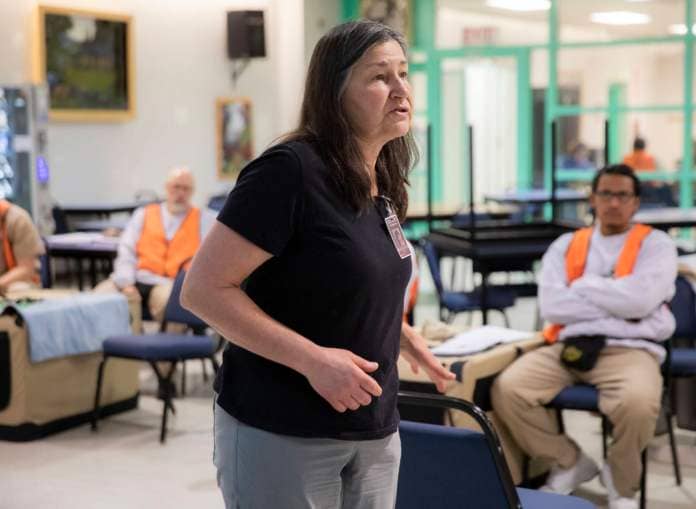 Sue Meinzinger, the founder and executive director Summit Assistance Dogs, talks prisoners through the first training exercise of the day during a weekly meeting of the Summit Assistance Dogs program at the Monroe Correctional Complex on Tuesday, Feb. 6, 2024 in Monroe, Washington. (Olivia Vanni / The Herald)