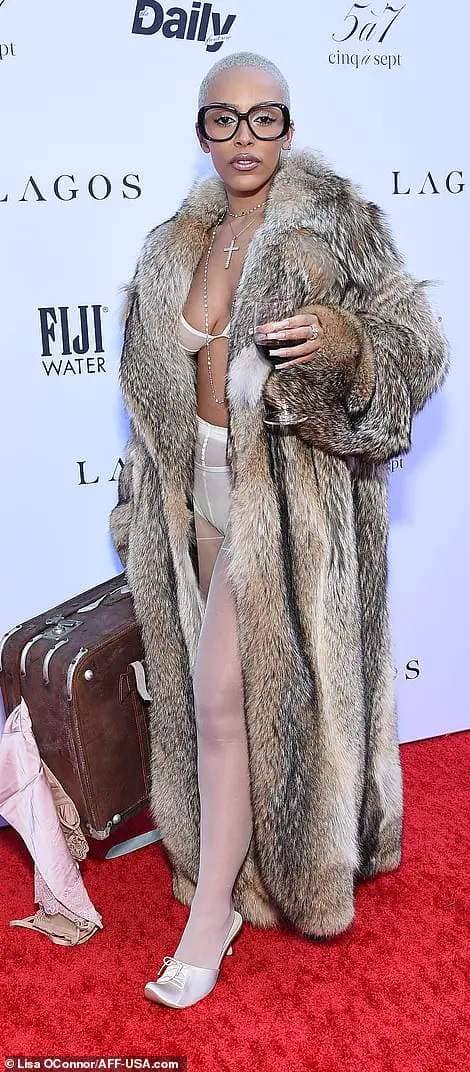 The 28-year-old singer made a striking arrival in a conceptual look in which she held a glass of red wine and carried a stuffed suitcase with clothing spilling out