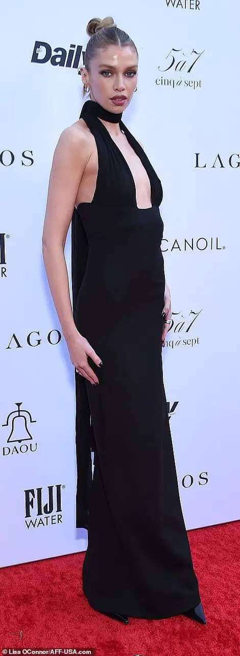 Stella Maxwell turned heads in a plunging and figure-accentuating black gown with a halter neck design