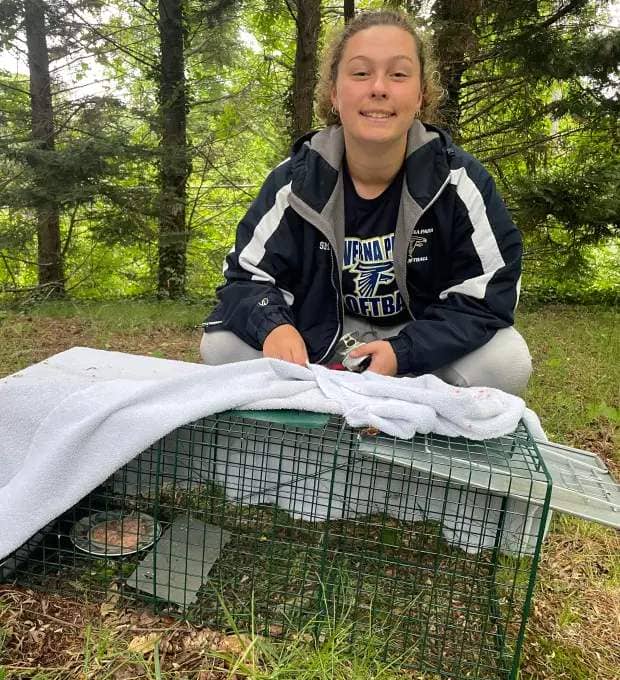 Ryleigh Smith checks on her cats. Smith is third in a maternal line of trappers, a volunteer who tends to colonies of cats in the neighborhood. (Courtesy photo)