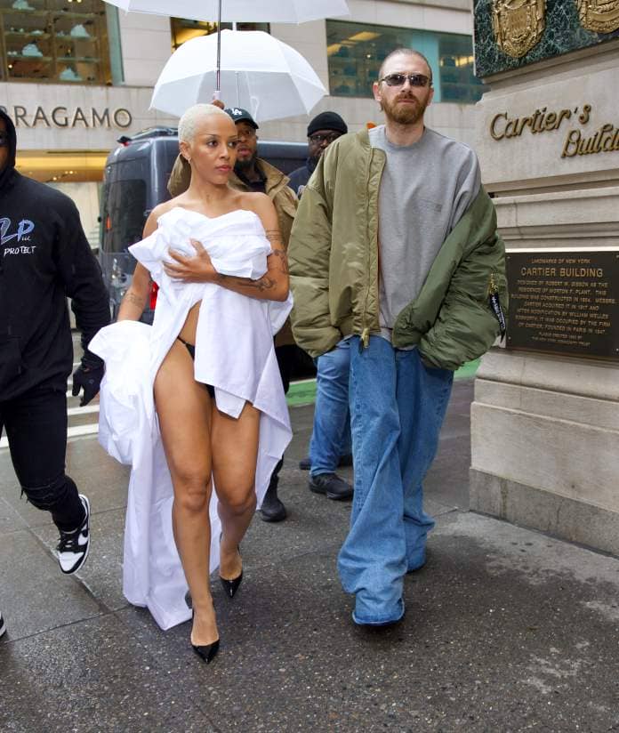 Doja Cat went topless and accidentally exposed her black thong as she went shopping wrapped in bed linen